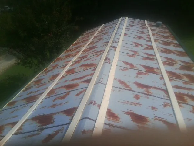 Rusted metal roof panels with new wood purlins before replacement — Storm Damage Roof Repair in Akron by Roofing Brothers